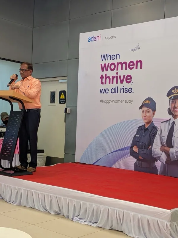 Dr. Ashok Sajnani speaking at the podium during International Women's Day event